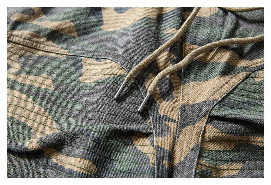 Close-up of camouflage shorts with tan drawstrings and stitched front panels.