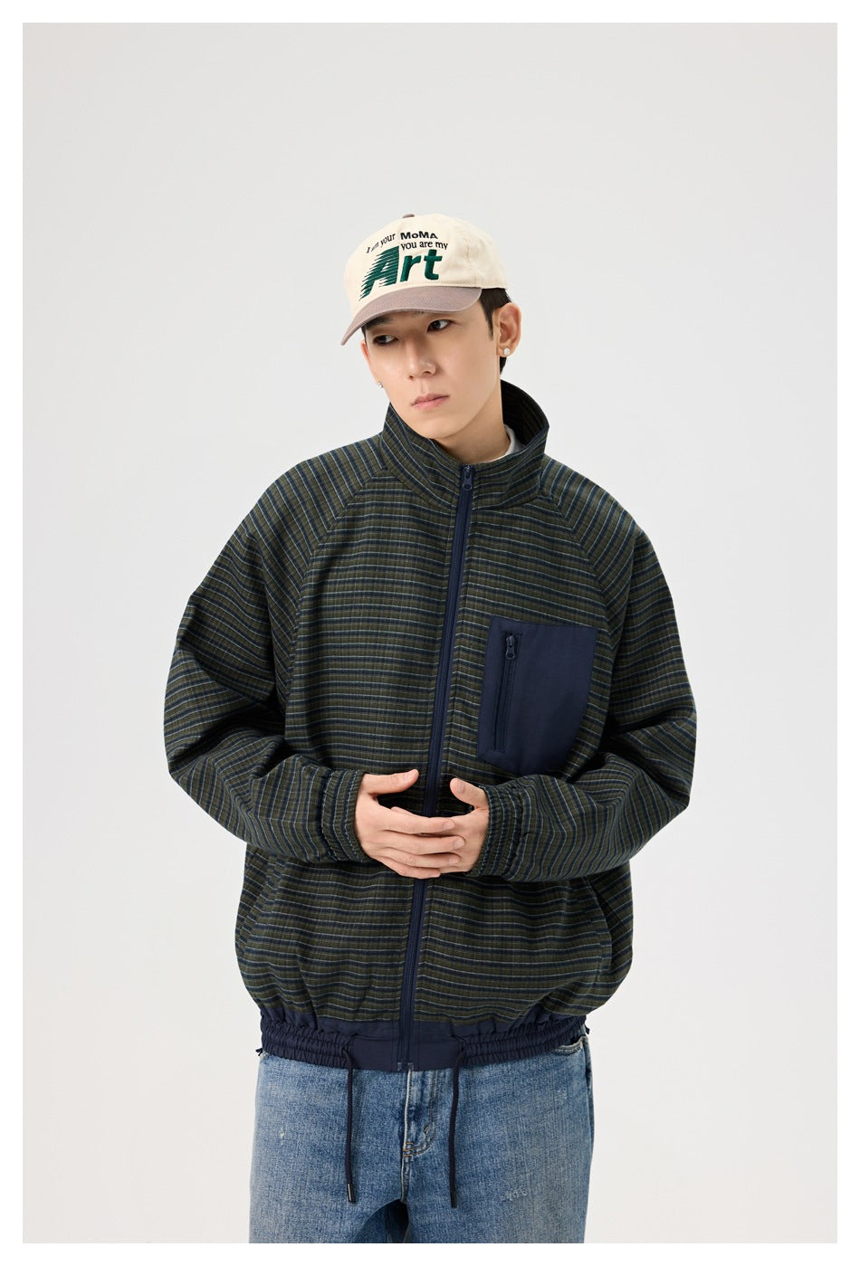 Model in a dark striped jacket with a stand collar, front zipper, navy chest pocket and elastic hem.
