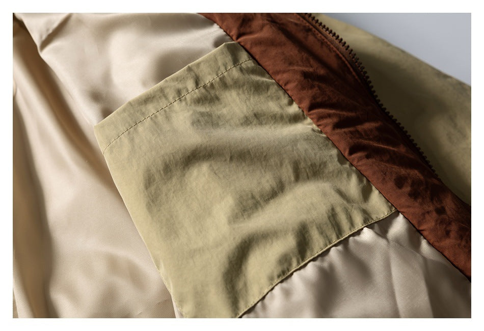 Close-up of a khaki jacket interior with a large stitched pocket and brown zipper trim.