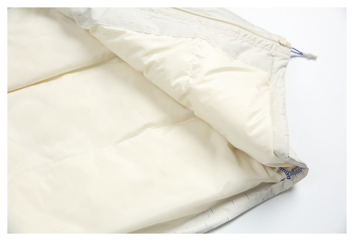 The off-white garment is opened to show its smooth pale lining and patterned outer shell.