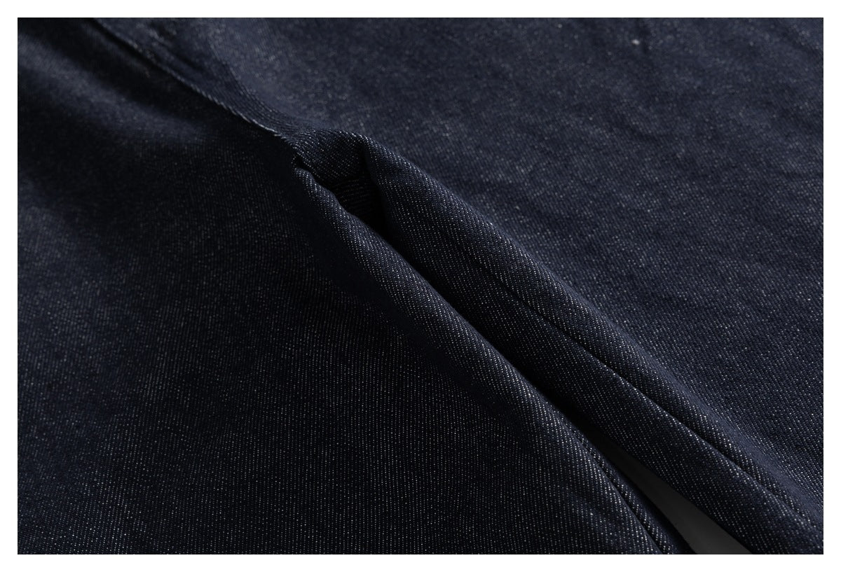 Extreme close-up of dark indigo denim fabric and a folded seam.