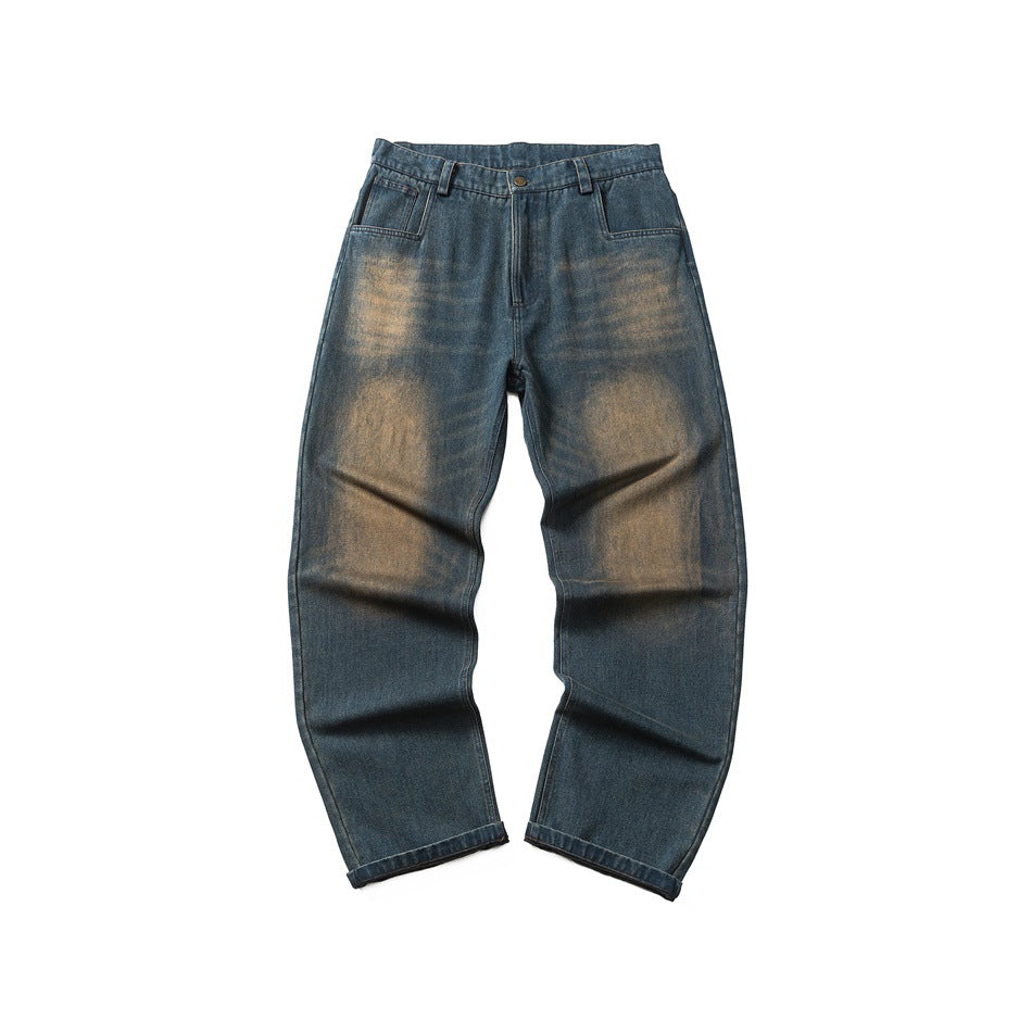Front of blue washed denim jeans with faded tan wash on thighs and knees, zip fly, button and front pockets