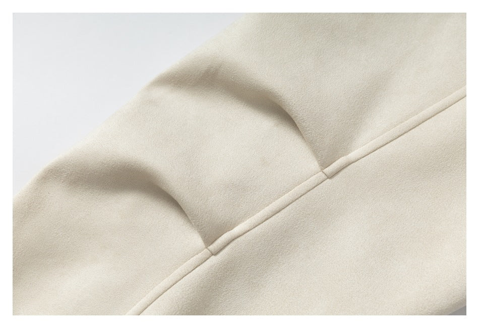 Close-up of a curved stitched seam on cream fabric.
