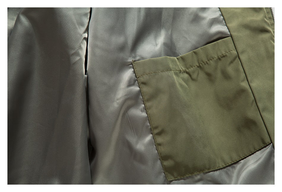 Close-up of the olive jacket's rectangular interior pocket against smooth gray lining.