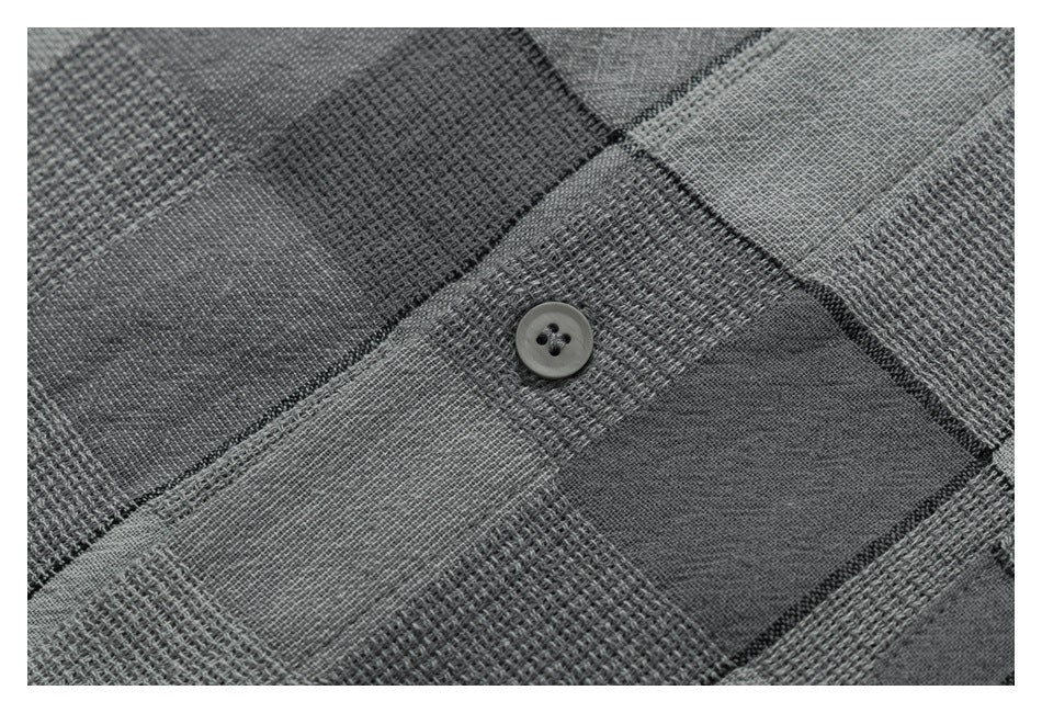 Close-up showing a gray shirt button against alternating woven and smooth checkered fabric panels.