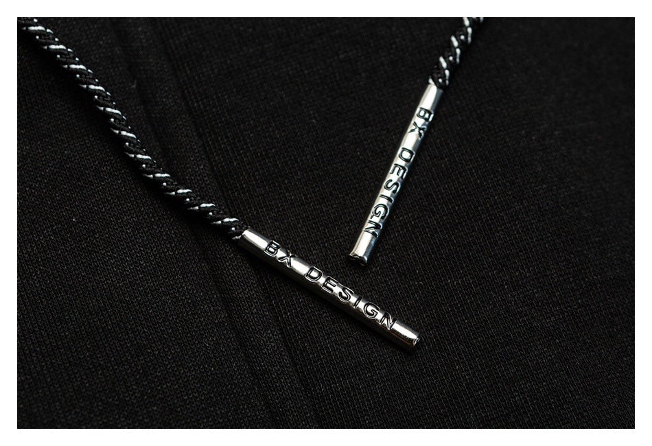 Close-up of black drawstrings with silver metal tips bearing English lettering.