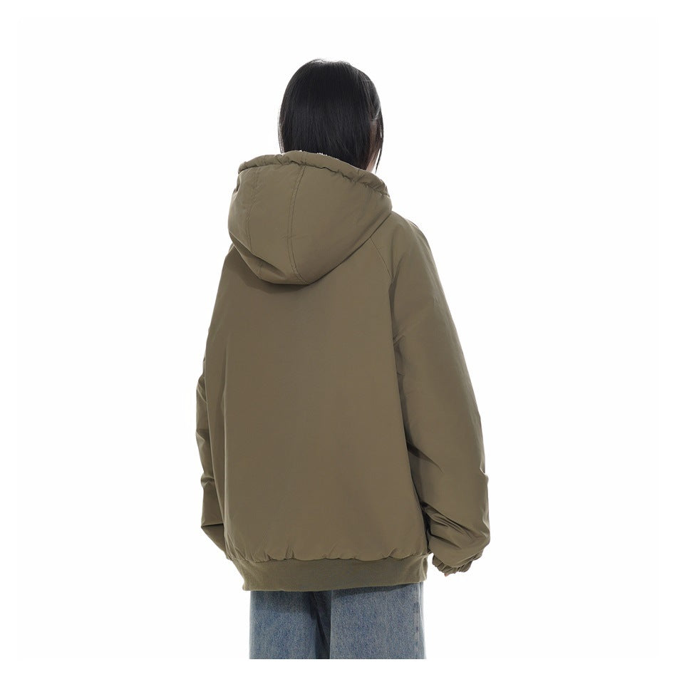Rear view of a model wearing an olive jacket with a hood and ribbed hem, paired with light-wash jeans.