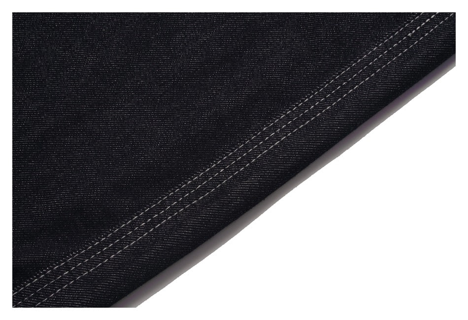 Close-up of black denim fabric and a double-stitched garment edge.