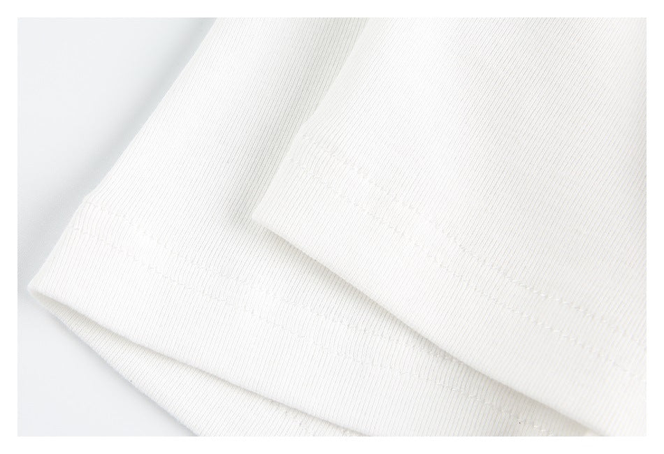 Close-up of the white T-shirt’s folded sleeve edge and double stitching.