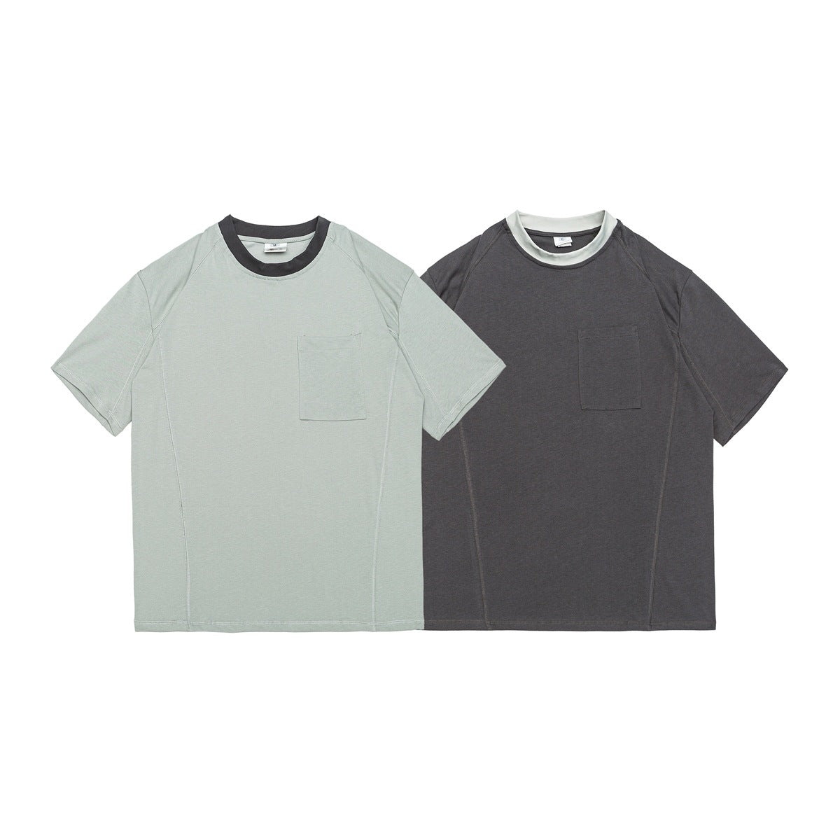 Two short-sleeve crew-neck shirts with chest pockets: pale sage with a dark collar and charcoal with a pale collar.