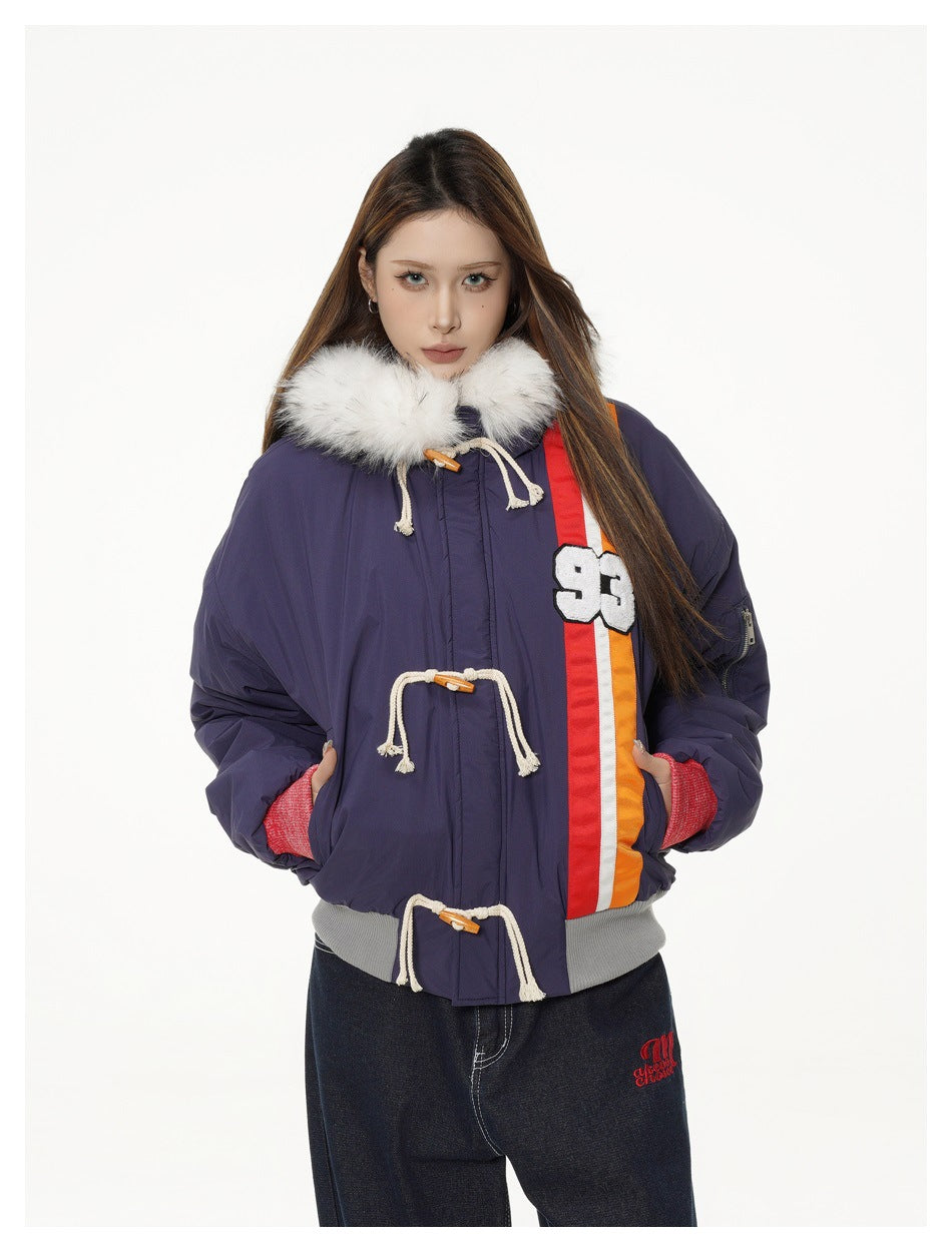 Front view of a model in a navy jacket with white fur trim, rope toggles and bold red-orange stripes.