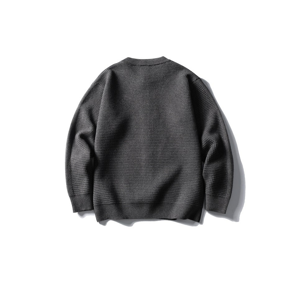 Back view of a dark gray waffle-knit cardigan with ribbed cuffs and hem, laid flat