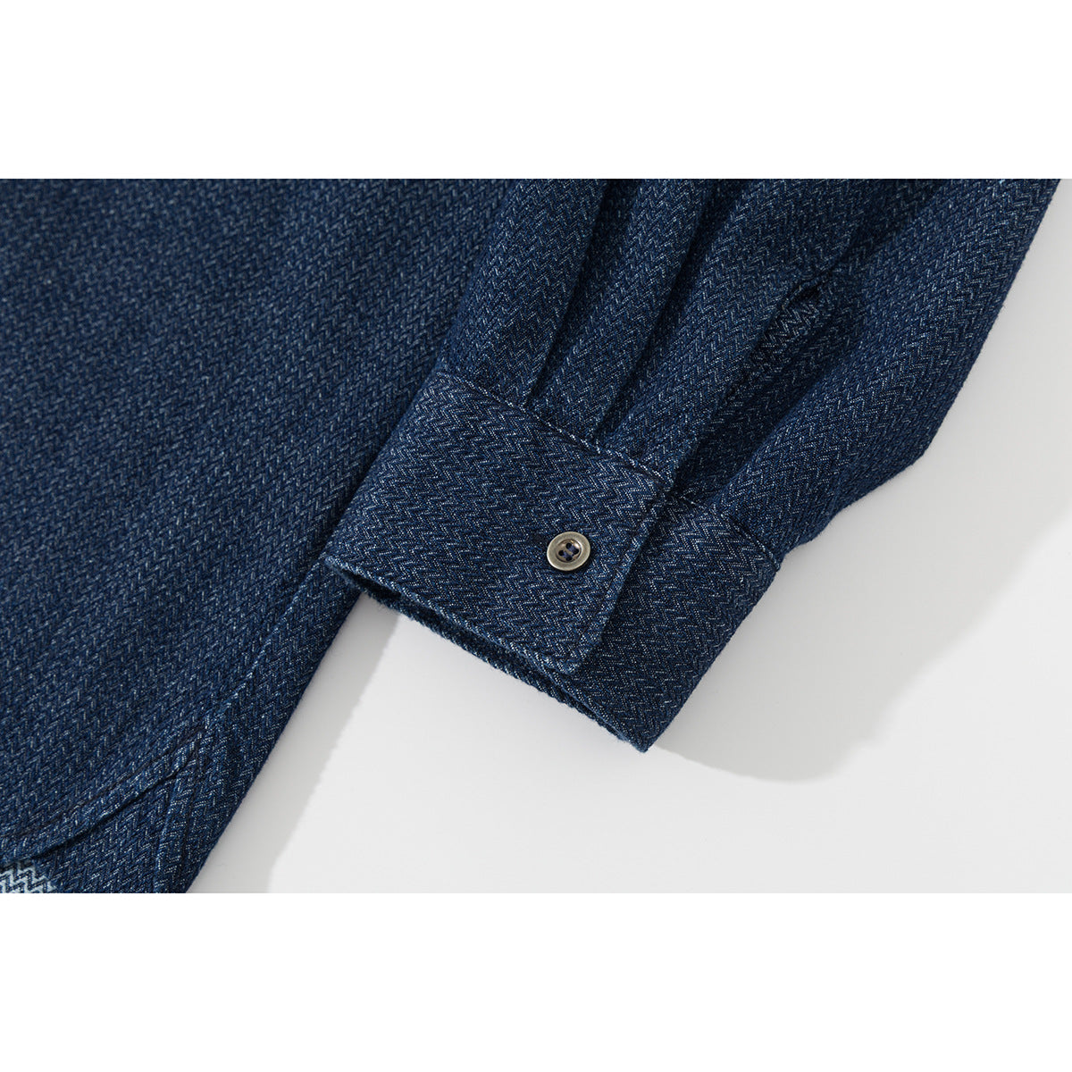Close-up of a dark blue patterned shirt sleeve and buttoned cuff.