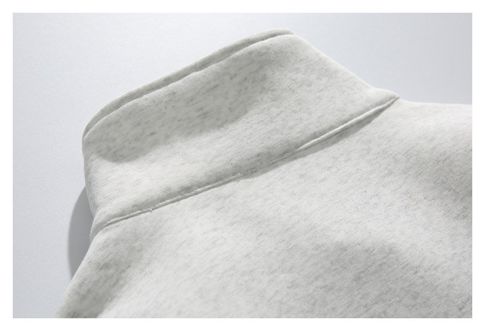 Close-up of the collar seam on a light gray heather garment.