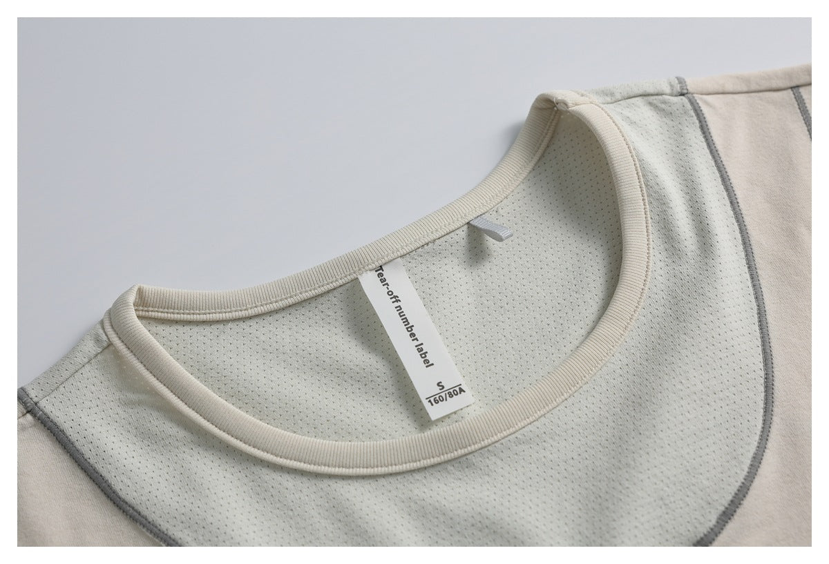Close-up of a light beige top's perforated inner panel, ribbed neckline and size label.