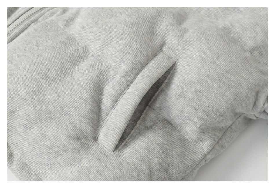 Close-up of a slanted welt pocket on the light gray heather jacket.