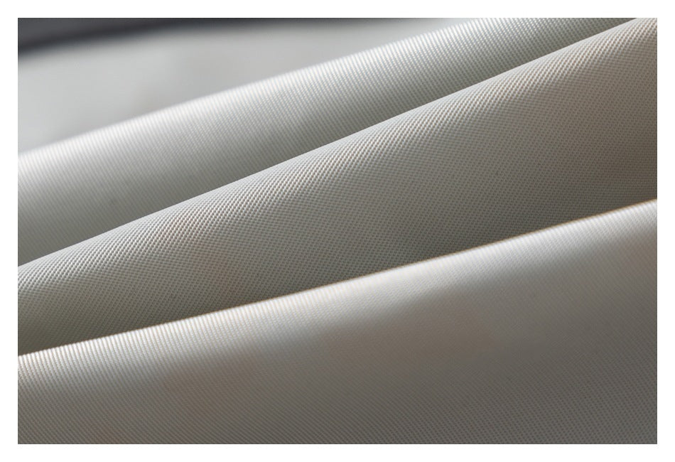 Close-up of pale gray fabric folded into ridges, showing a fine, uniform woven texture.