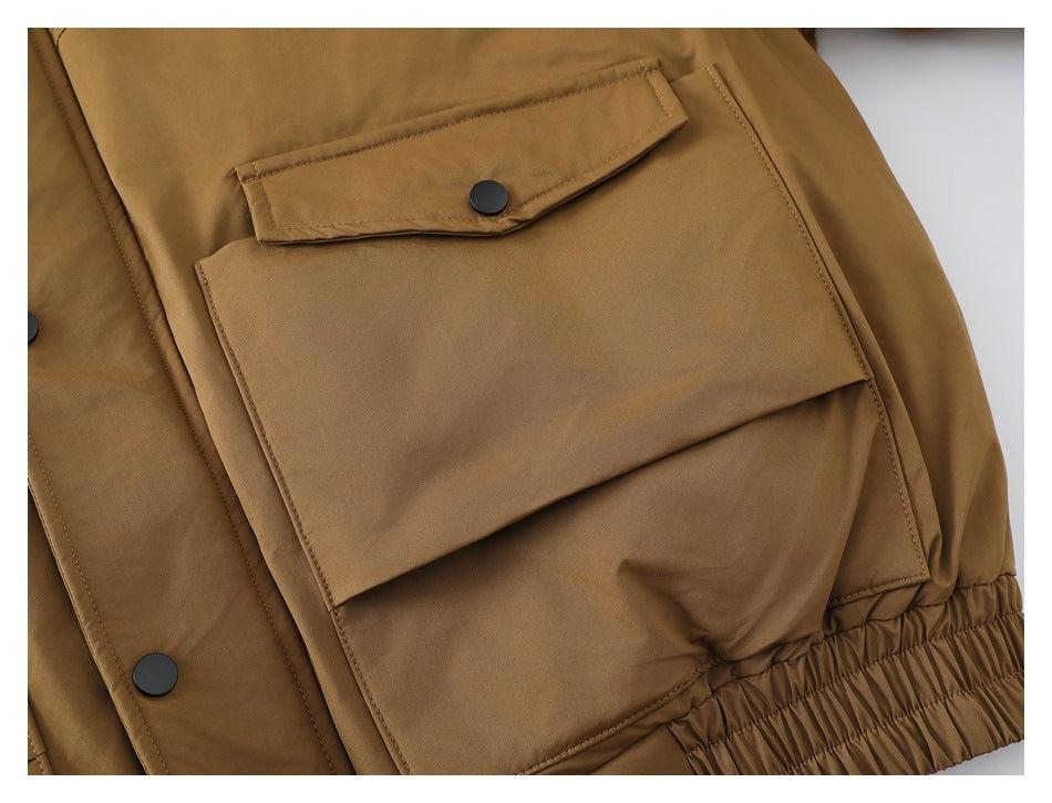 Close-up of a large flap pocket with a black snap on the tan jacket.