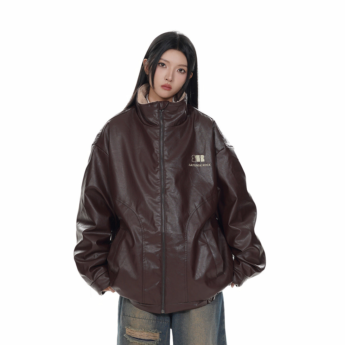 Model wearing an oversized dark brown zip-front jacket with a tall collar and curved front pockets.