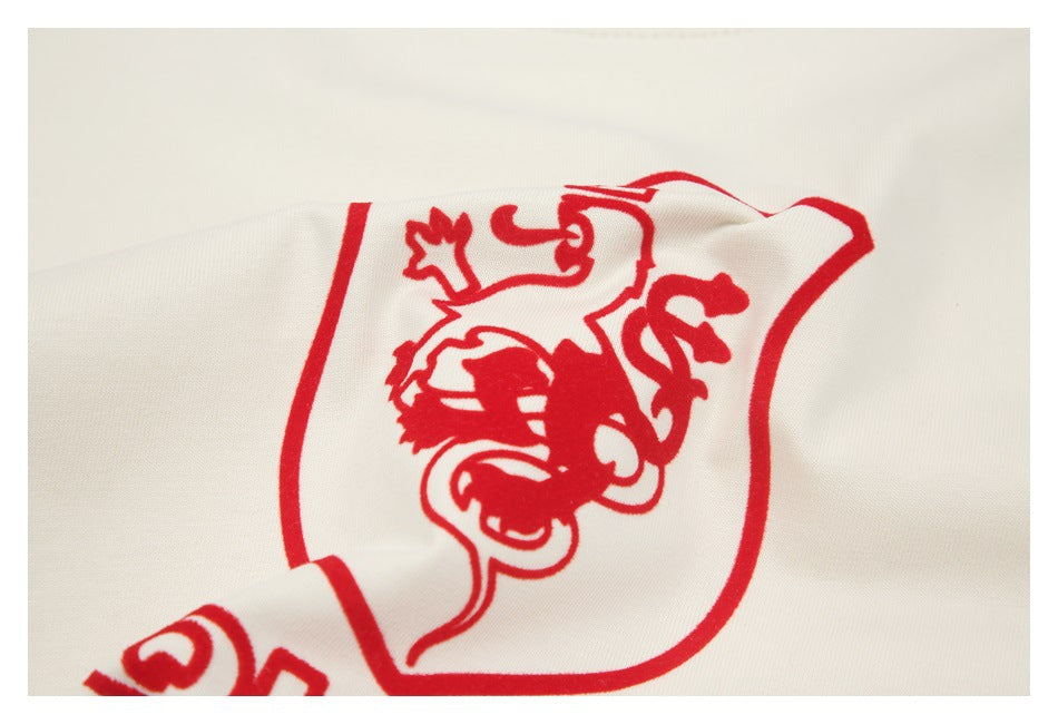 Close-up of a red heraldic crest printed on slightly folded off-white fabric.