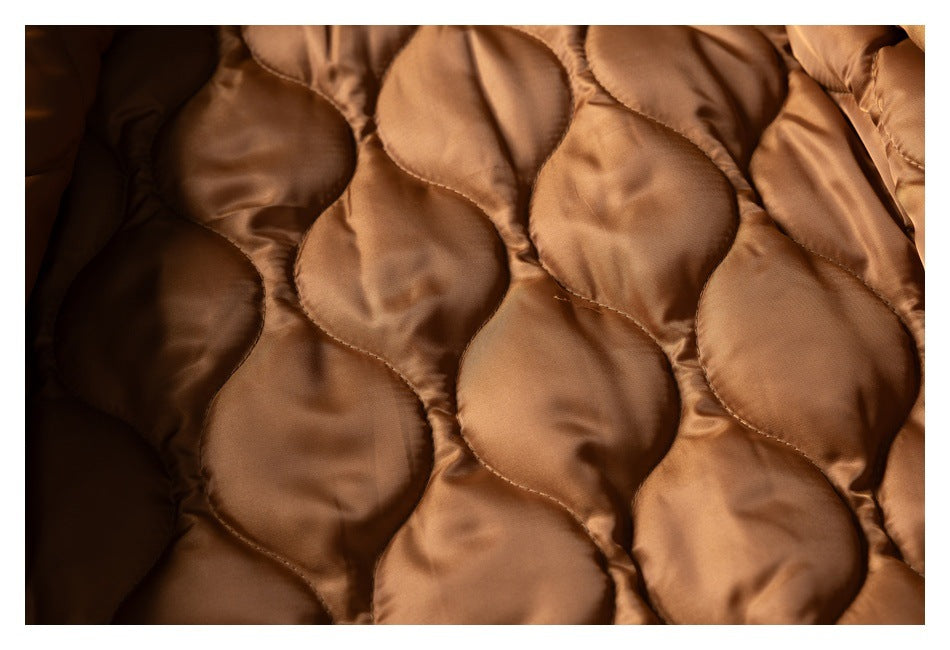Close-up of the brown jacket's quilted lining with rounded stitched panels.