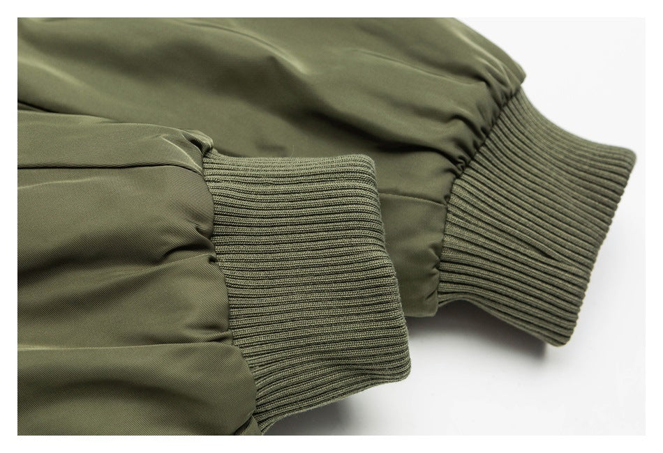 Close-up of olive jacket sleeves with gathered fabric and wide rib-knit cuffs.