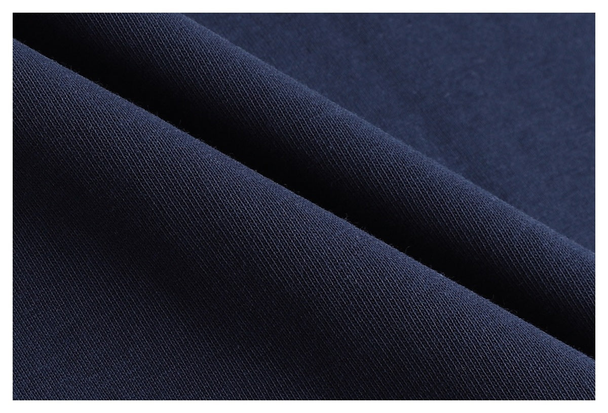 Macro view of dark navy fabric folded to show its fine knit texture.