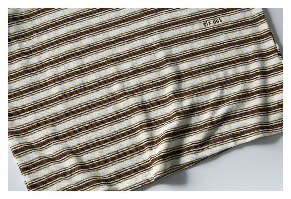 Close-up of the striped shirt's lower body and hem, with small embroidered lettering near the edge.
