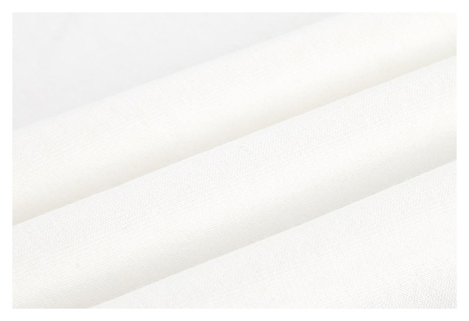 Close-up of white fabric folded into diagonal ridges, showing its fine textured surface.