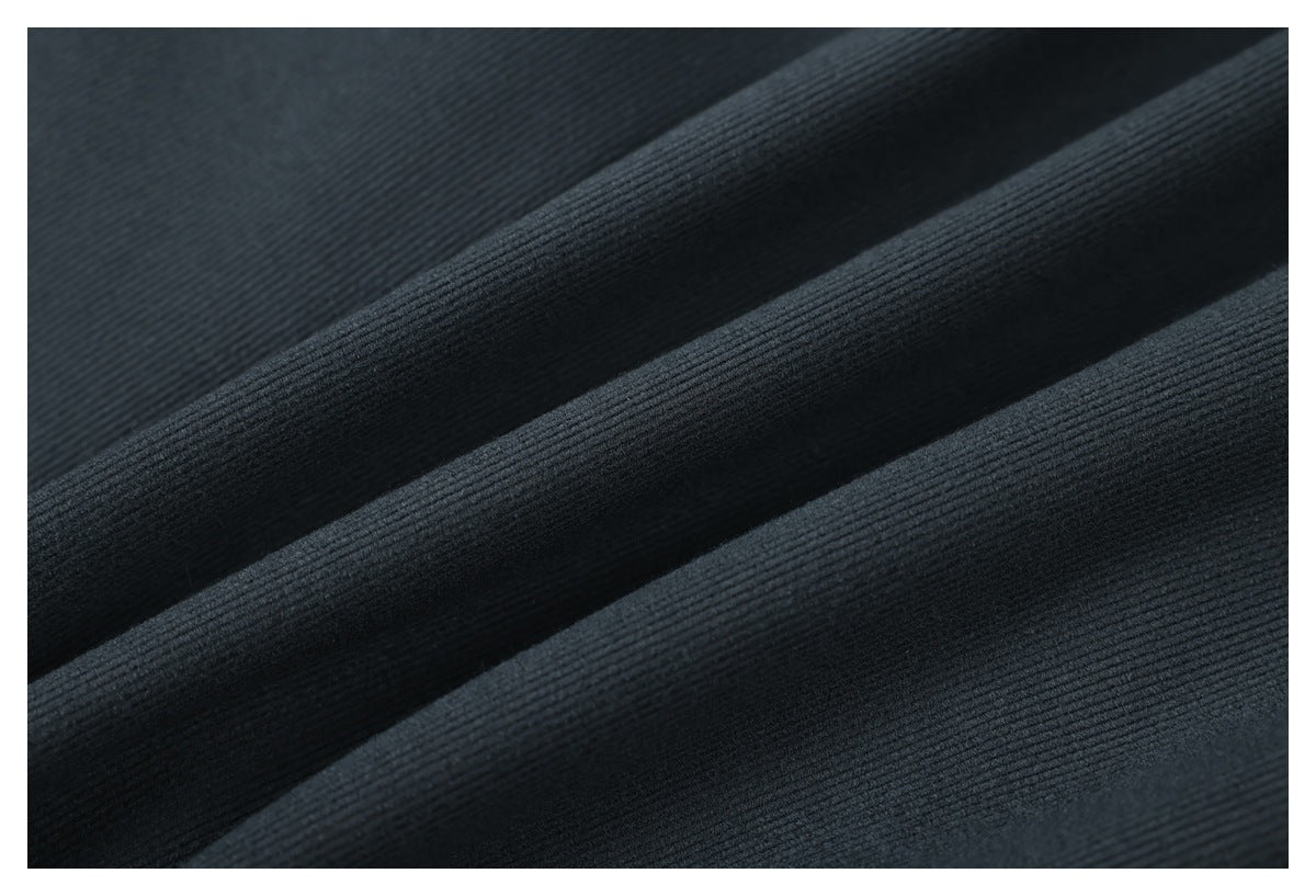Macro view of dark charcoal fabric showing its fine ribbed texture and folds.