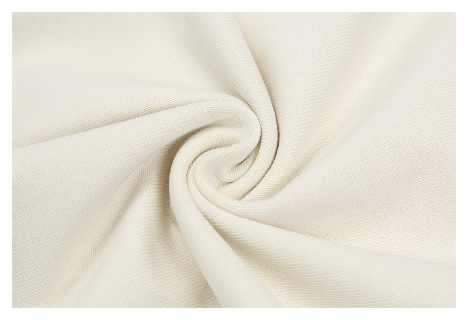 Close-up of ivory fabric gathered into a spiral to show its surface texture.