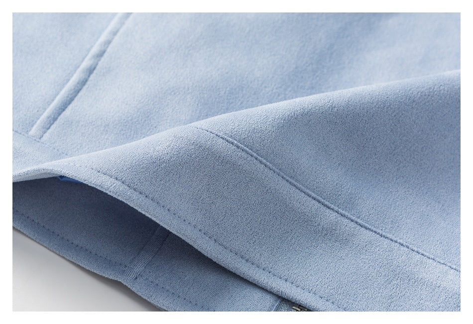 Close-up of a folded light blue jacket hem with visible stitching and a partial zipper.