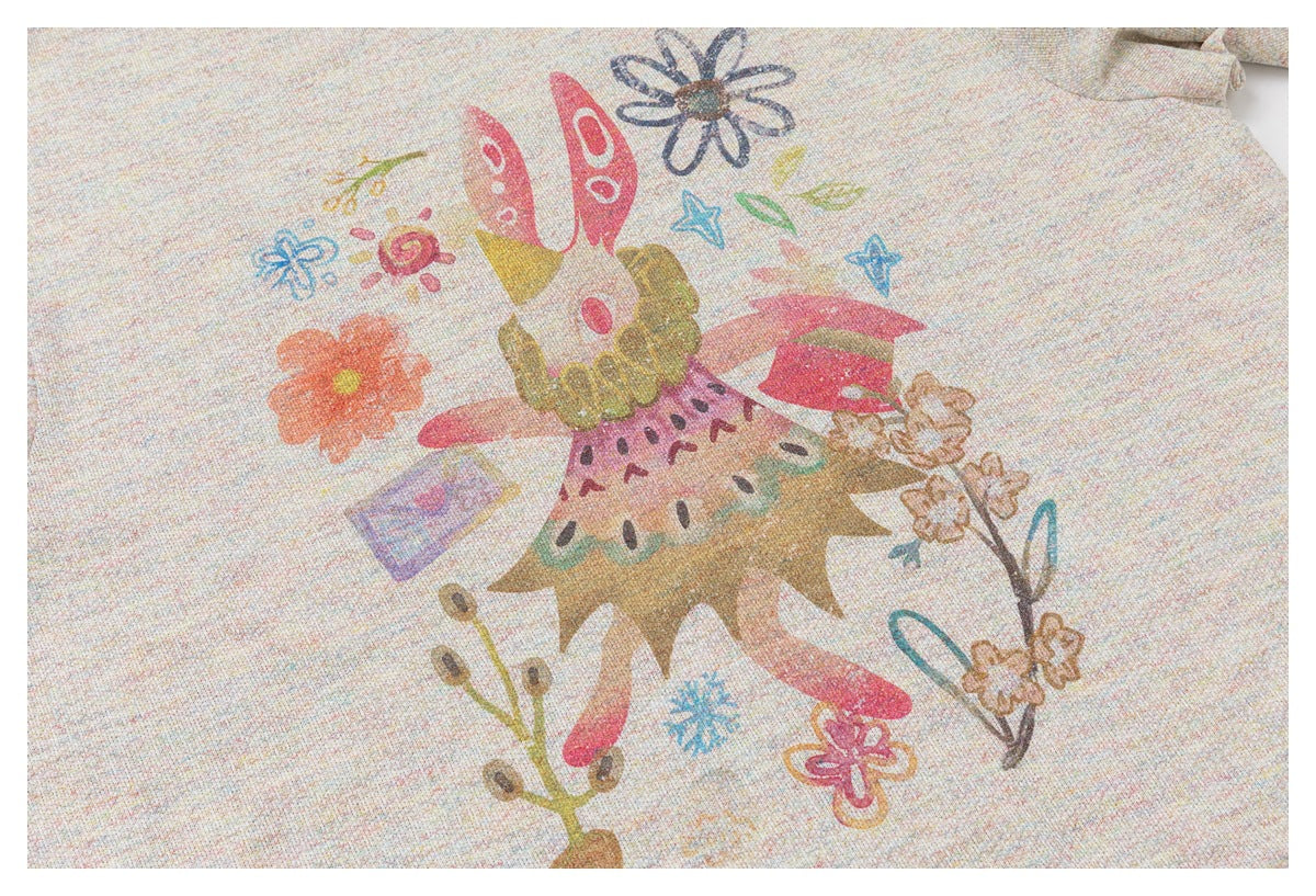Close-up of a colorful whimsical floral and character illustration printed on the light oatmeal top.
