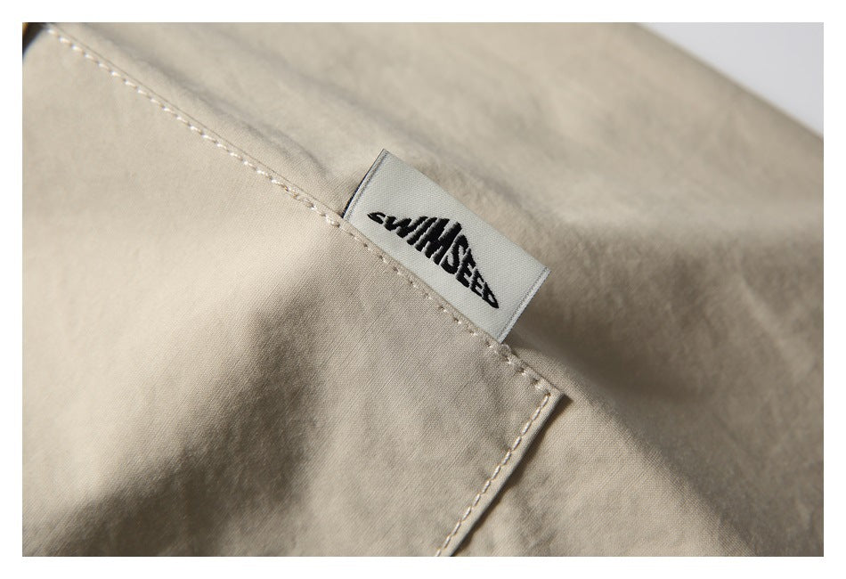 Close-up of a sewn black-and-white brand label on beige fabric.