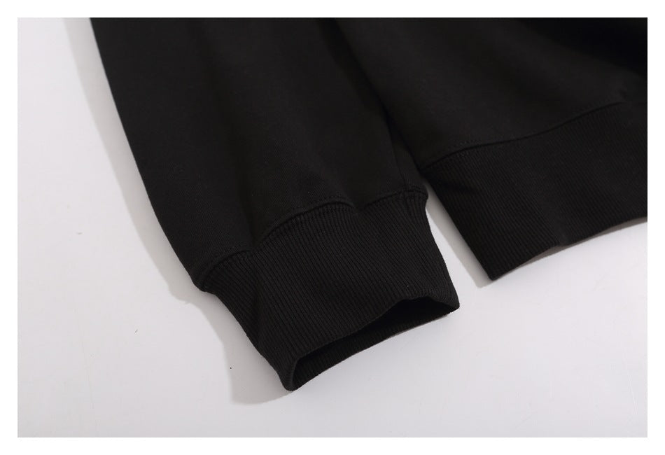 Close-up of the black sweatshirt’s ribbed sleeve cuffs and stitched seams.