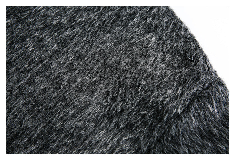 Close-up of fuzzy charcoal garment fabric with a curved seam near the edge.