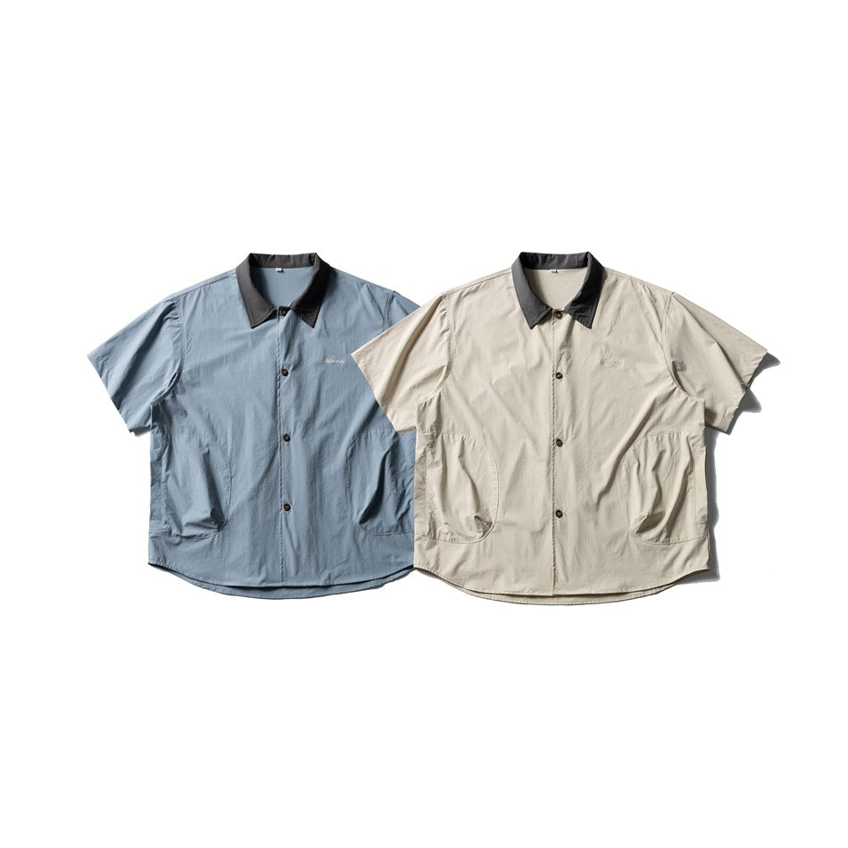 Two short-sleeve button-up shirts laid flat: one light blue and one pale beige, both with charcoal collars and front pockets.