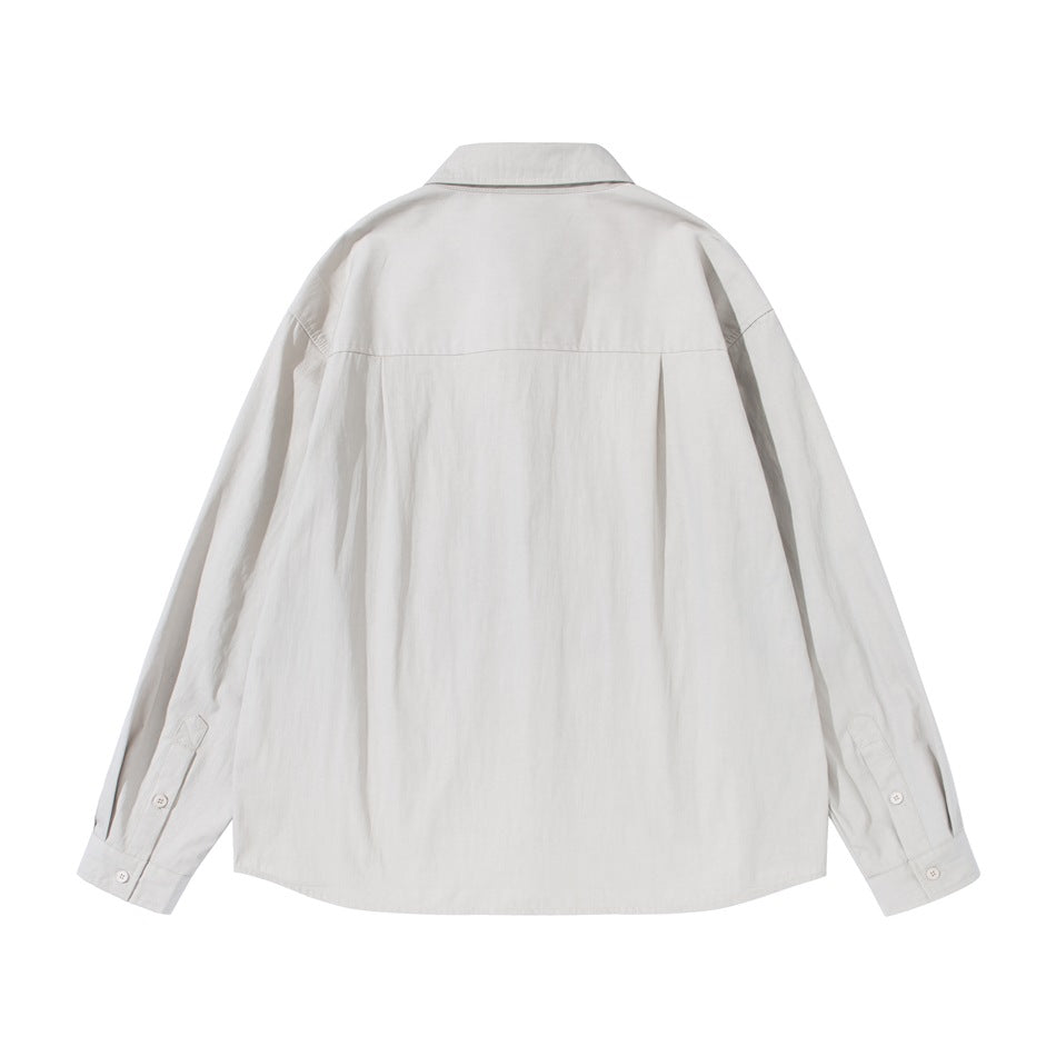 Back view of light gray button-up shirt showing yoke seam, center pleat and buttoned cuffs