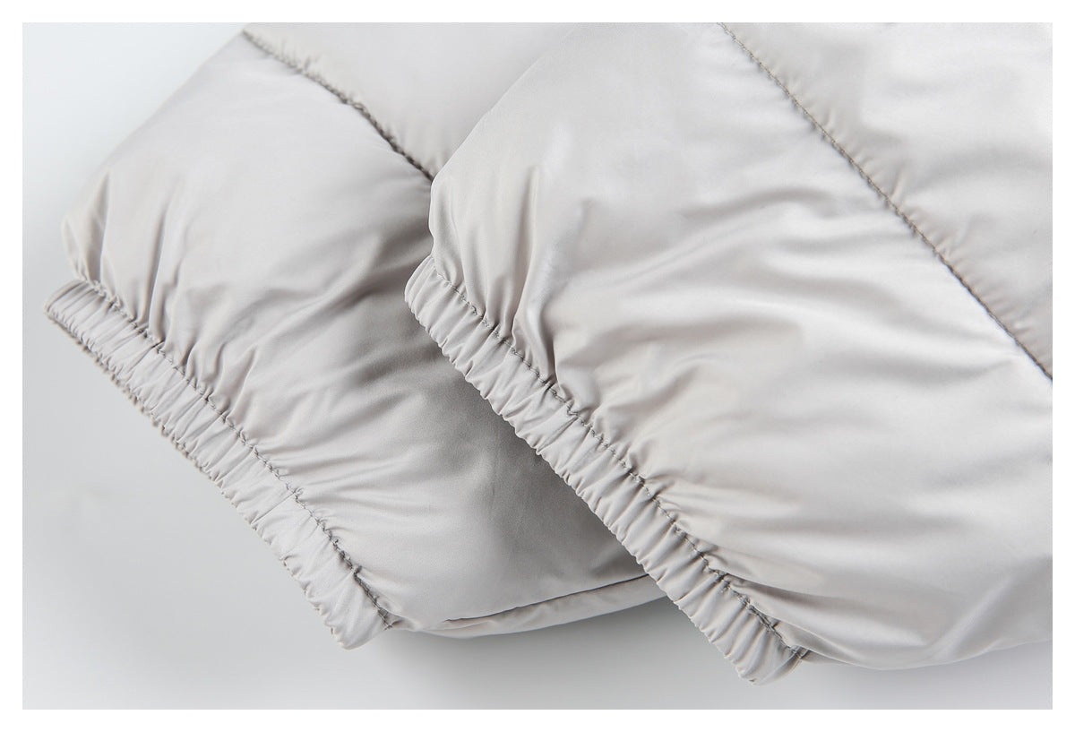 Close-up of the gathered edge and stitched panels on a light gray padded garment.