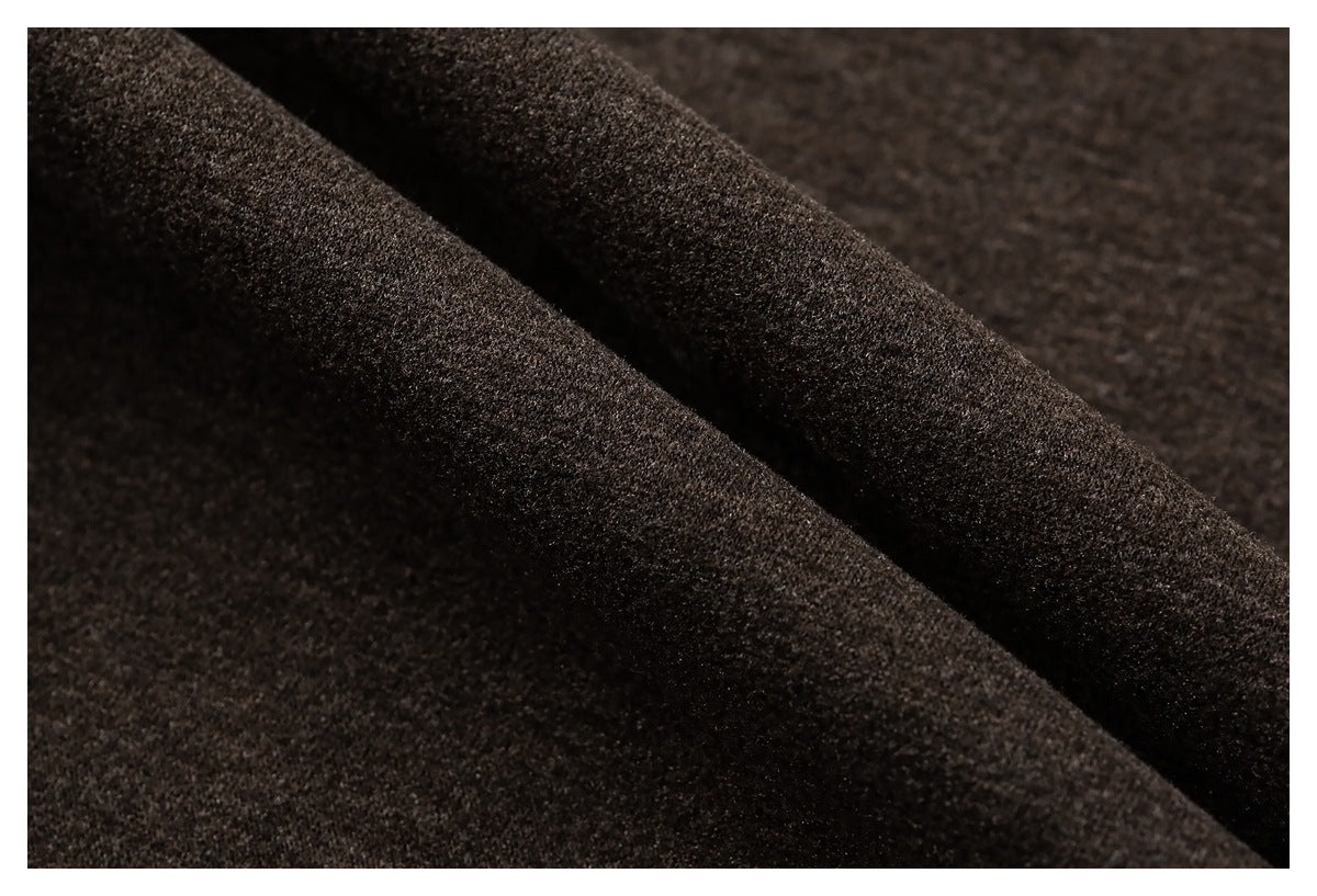 Close-up of dark brown, softly textured fabric folded into diagonal ridges.