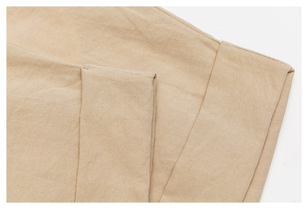 Close-up of folded tan trouser fabric showing seams and a folded edge.