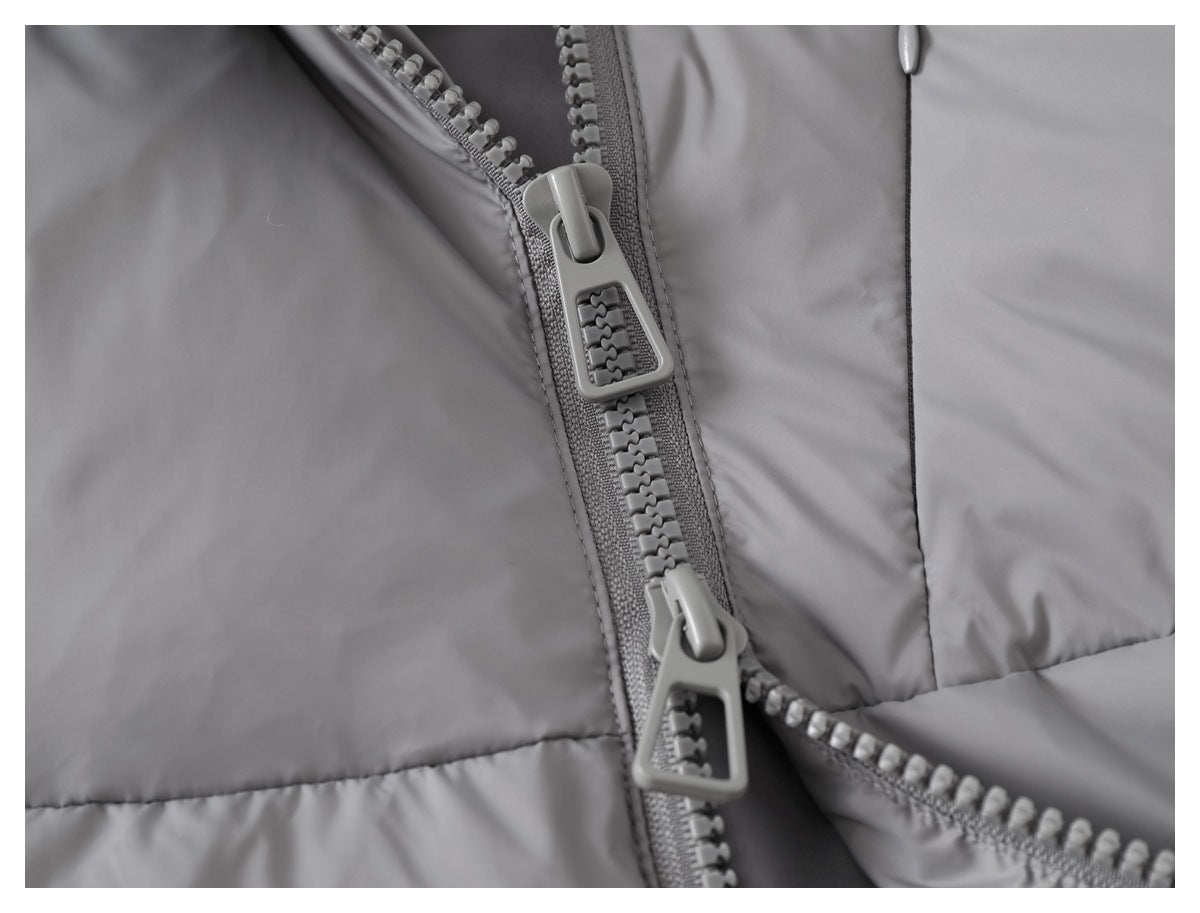 Close-up of a gray jacket with a chunky front zipper and two oversized zipper pulls.
