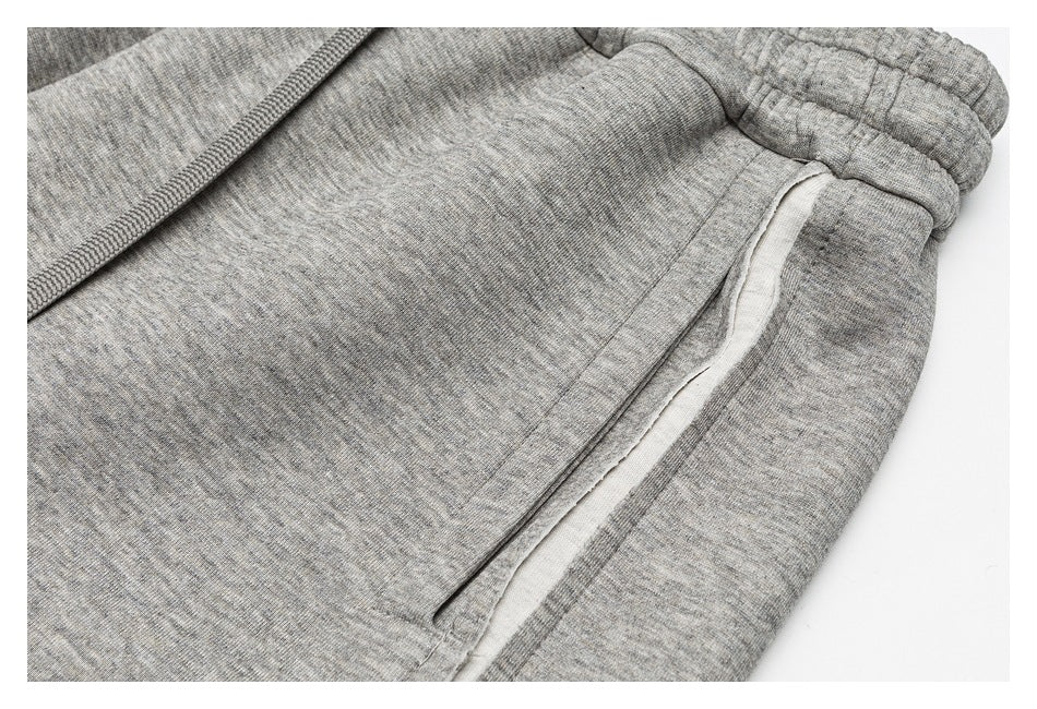 Close-up of gray heathered pants showing the elastic waistband, drawstring, and pocket opening.