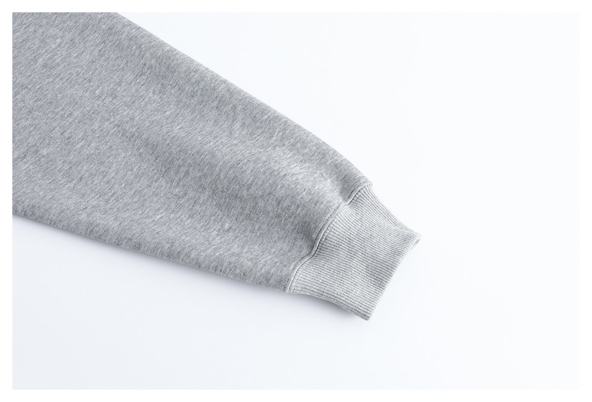 Close-up of a heather gray sweatshirt sleeve ending in a ribbed cuff.