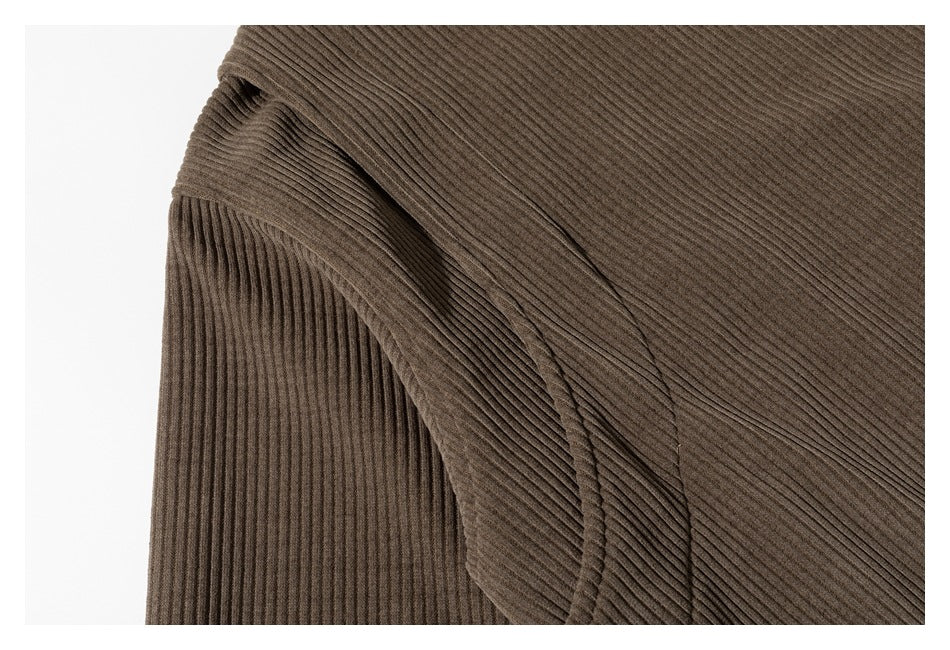 Close-up of a curved overlapping seam on a brown ribbed garment.