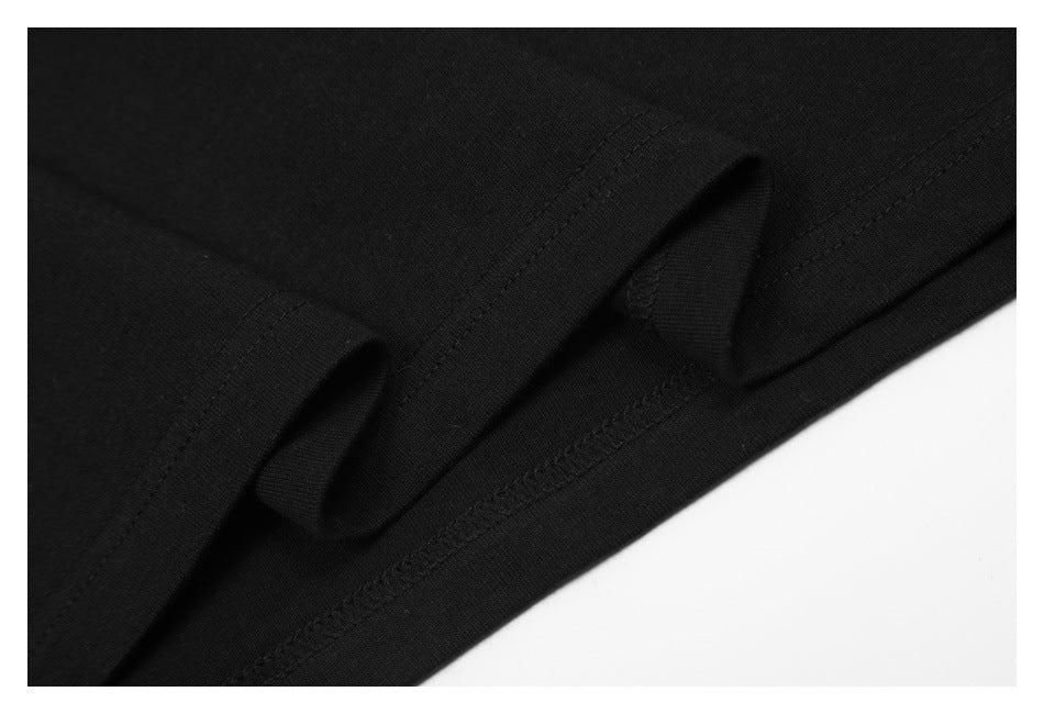 Close-up of black garment stitching and two small folded fabric loops near the hem.
