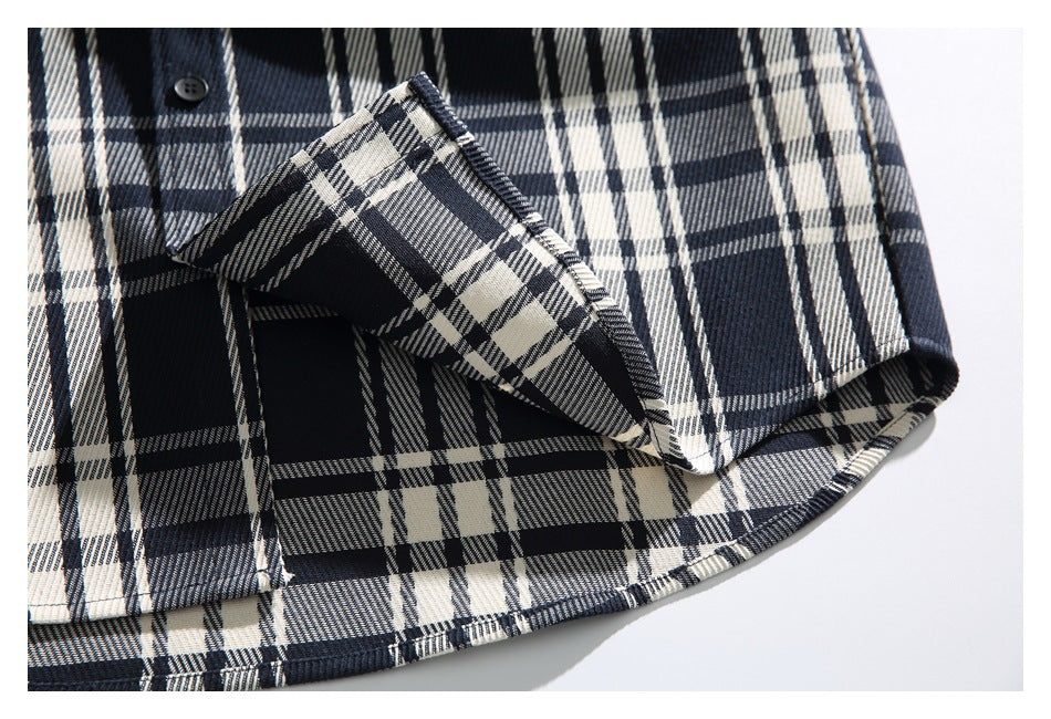 Close-up of the plaid shirt's buttoned body and folded sleeve edge.