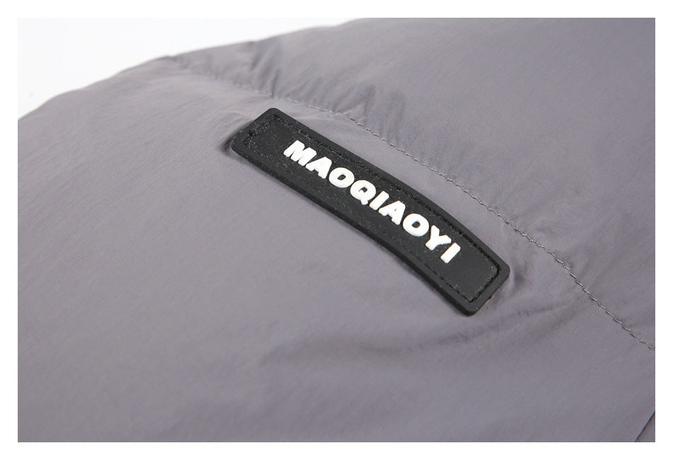 Close-up of a black MAQIAOYI brand patch on gray jacket fabric.