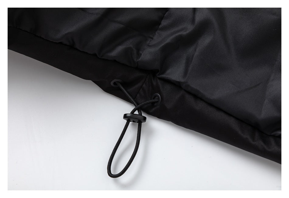 Close-up of a black garment hem with an adjustable elastic drawcord and toggle.