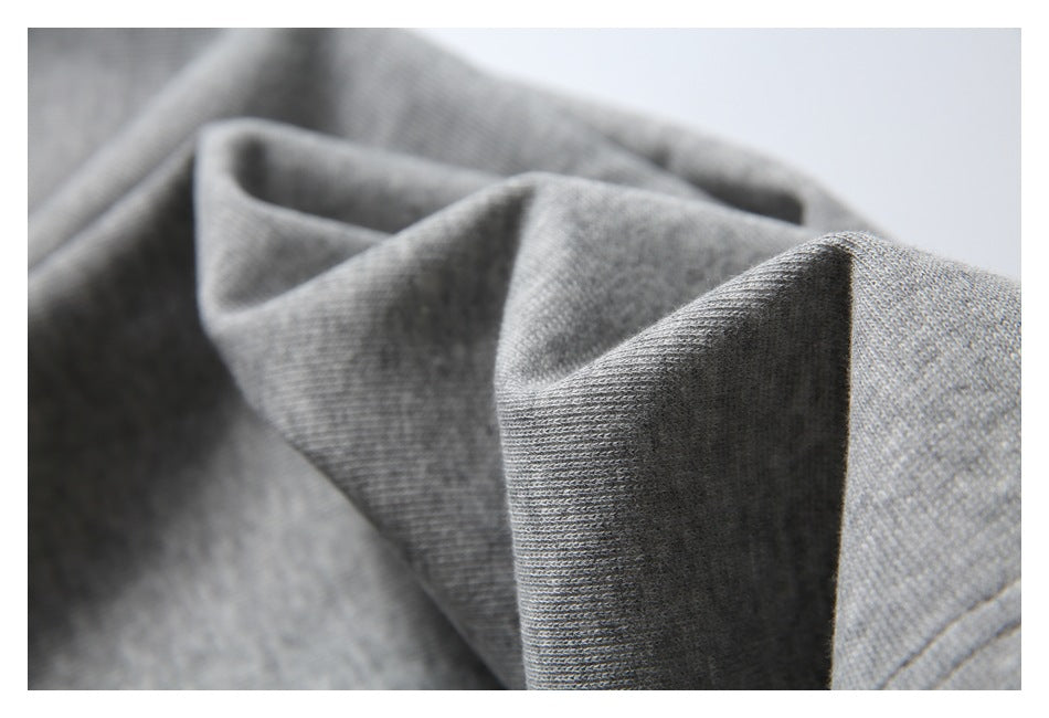 Macro view of folded gray fabric showing its knit texture and stitching.